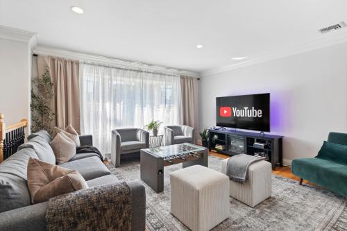 a living room with a couch and a tv at New Beach Home near Stamford Downtown/Shippan in Stamford