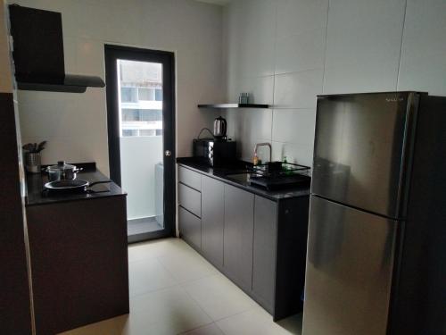 cocina con nevera de acero inoxidable en Imperial suites@Reizz residence, en Kuala Lumpur