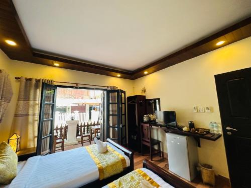 a hotel room with a bed and a balcony at Villa Ban Pakham Hotel in Luang Prabang