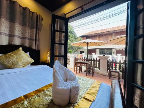 a bedroom with a bed and a view of a patio at Villa Ban Pakham Hotel in Luang Prabang