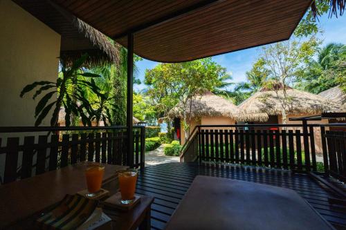 a balcony of a resort with a table and drinks at Tup Kaek Sunset Beach Resort-SHA Plus in Tab Kaek Beach