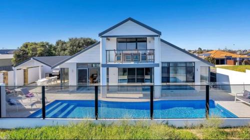 a house with a swimming pool in front of it at Beachfront Bliss - Private Pool and Beach Access in Mandurah