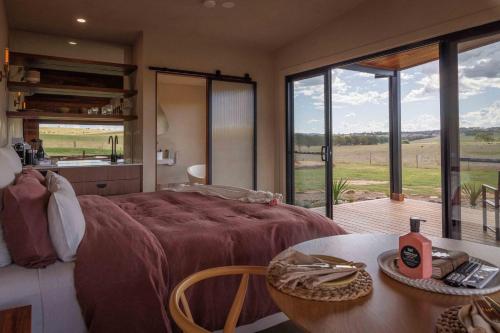 Un dormitorio con una cama grande y una mesa con mesa. en Rest Private Escape at BoxGrove, en Bathurst