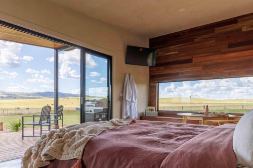 a bedroom with a large bed and a large window at Rest at BoxGrove in Bathurst