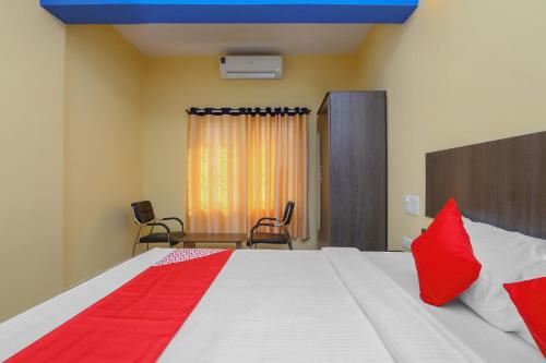 - une chambre avec un lit doté d'oreillers rouges dans l'établissement Collection O 19289 The Olive Grand, à Mysore