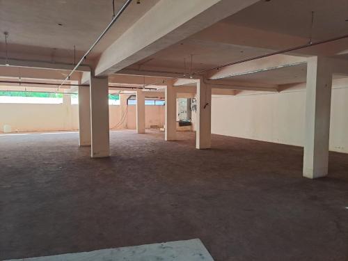 an empty room with white pillars in an empty building at Galeela Plaza in Tāmarakulam
