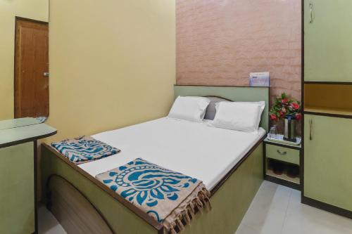KāyankulamにあるOYO HOTEL RAGAの小さなベッドルーム(白いシーツ付きのベッド1台付)