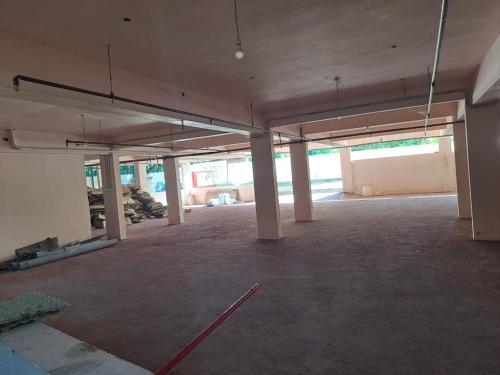 an empty room with white pillars in a building at Galeela Plaza in Tāmarakulam