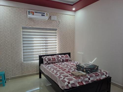 a bedroom with a bed with a blanket on it at Galeela Plaza in Tāmarakulam