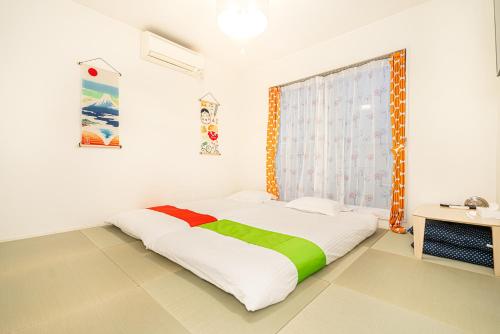 a white room with a bed with a window at 両国駅前 in Tokyo