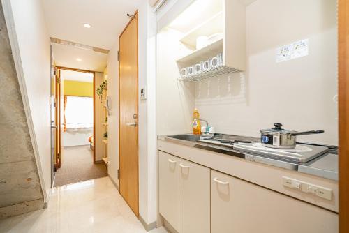 a white kitchen with a stove and a sink at 両国駅前 in Tokyo