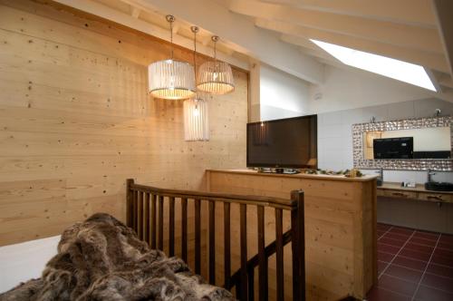 a kitchen with wooden walls and a television and chandeliers at Auberge De Maison Rouge in Vétraz-Monthoux