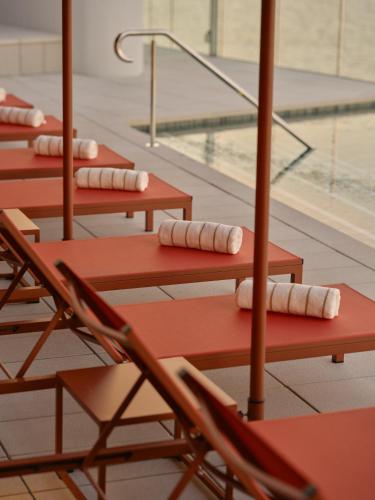 a row ofoccupied chairs with towels on them next to a swimming pool at Ardo in Townsville