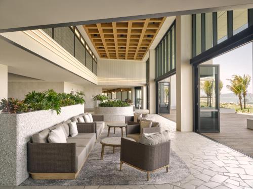 an open lobby with couches and chairs and plants at Ardo in Townsville