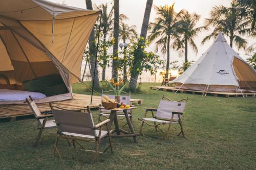 a tent and two chairs and a table with a tent at Villa CBT tại Flamigo Dai Lai Resort in Phúc Yên