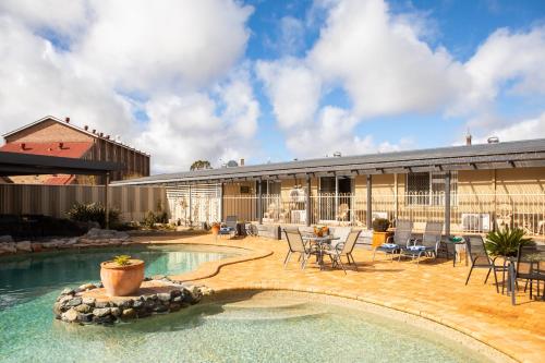 a house with a swimming pool and a patio at New England Motor Lodge in Glen Innes