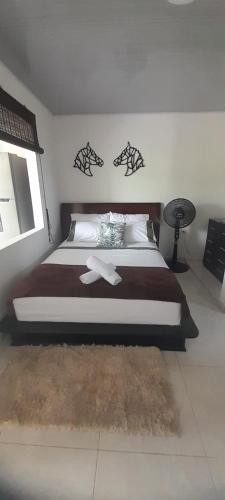 Un dormitorio con una cama grande con dos cruces. en apartamento tranquilo rodeado de zonas verdes, en Acacías