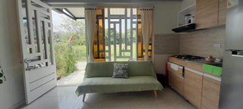 a kitchen with a green chair in front of a door at apartamento tranquilo rodeado de zonas verdes in Acacías
