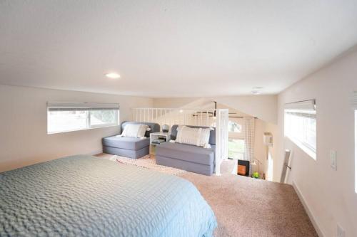 a bedroom with a bed and a couch in it at Peaceful Tiny Home Loft and Sauna in San Luis Obispo