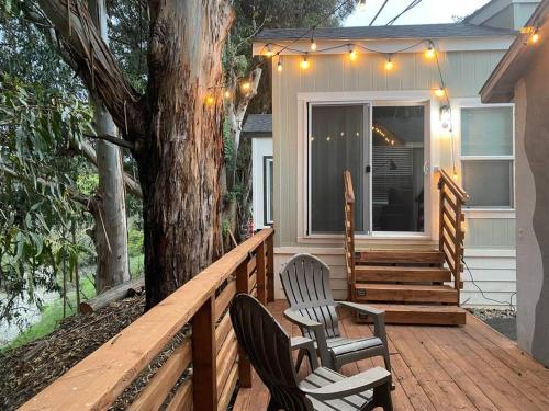 a porch with two chairs and a tree with lights at Peaceful Tiny Home Loft and Sauna in San Luis Obispo