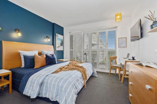 a bedroom with a bed with a blue wall at Resort on the Beach Dual Unit 5203 in Kingscliff