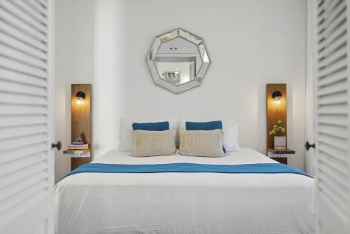 a bedroom with a white bed with a mirror on the wall at Bridget House in Coffs Harbour