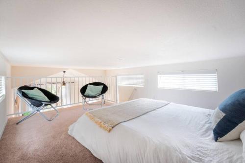 ein Schlafzimmer mit zwei Stühlen neben einem Bett in der Unterkunft The BEST Tiny Home with 2 Queens in San Luis Obispo