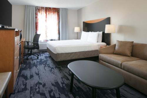 Fairfield Inn Manhattan, Kansas في مانهاتن: غرفه فندقيه بسرير واريكه