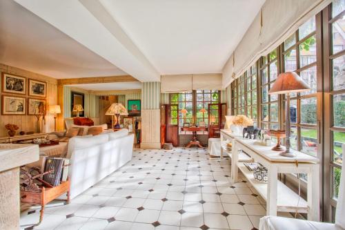 - un salon avec des fenêtres et un canapé dans l'établissement L'Oasis - Deauville Centre - Garden, à Deauville