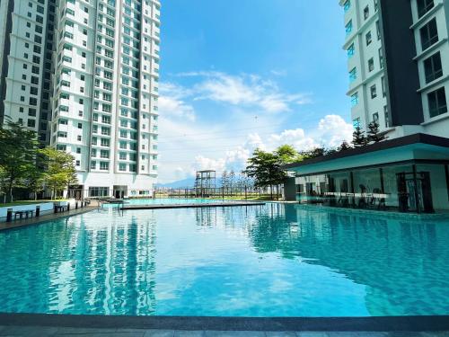 une grande piscine au milieu de deux grands bâtiments dans l'établissement D'Rapport Residences by Manhattan Plus, à Kuala Lumpur