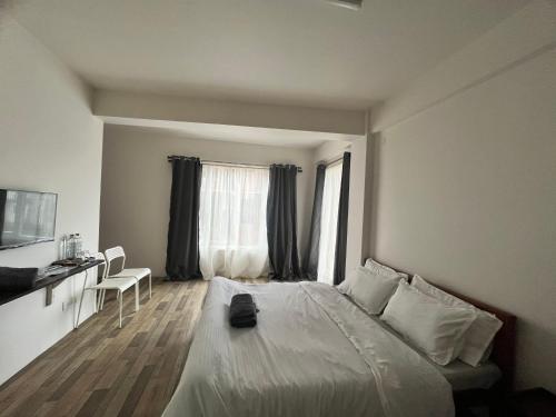 een slaapkamer met een bed, een bureau en een raam bij Mulberry Inn BnB in Shillong
