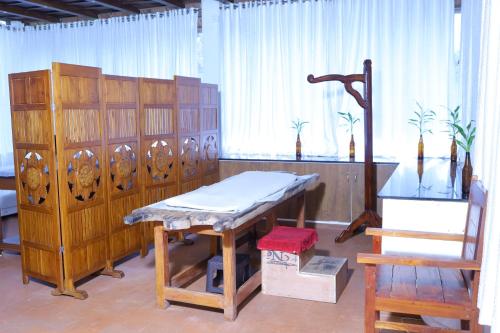 a room with a table and a chair and a desk at Vajra Ayurveda and Yoga Retreat in Cochin