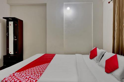 a bedroom with a bed with red and white pillows at OYO Flagship Larica Green Valley in Guwahati