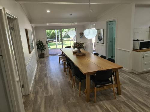 a kitchen and dining room with a wooden table and chairs at Hillview on Delany in Bright