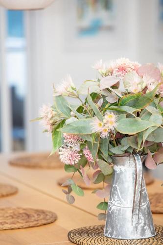 a vase filled with flowers sitting on a table at Hillview on Delany in Bright