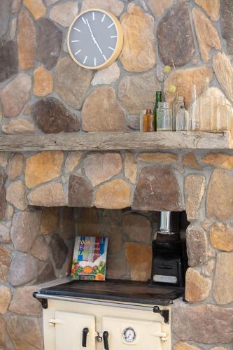 a clock on a stone wall above a stove at Hillview on Delany in Bright