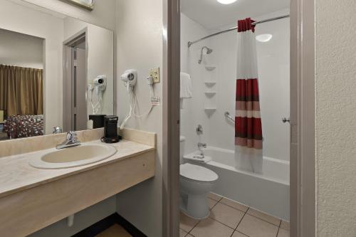 La salle de bains est pourvue d'un lavabo, de toilettes et d'une douche. dans l'établissement Red Roof Inn & Suites Cave City, à Cave City