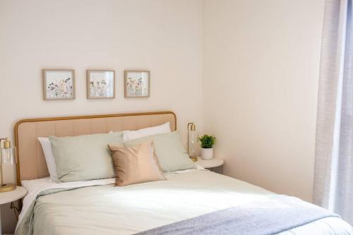 a bedroom with a bed with white sheets and pillows at Modern 2-Bedroom Eucalyptus House in San Luis Obispo