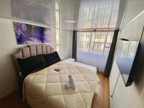 um quarto com uma cama com um urso de peluche em EmbajadaUsacorferiasAeropuertoG12Agora em Bogotá