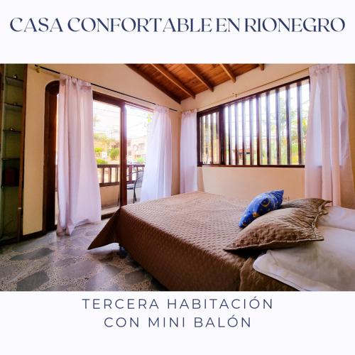 里奧內格羅的住宿－Casa Confortable en Rionegro - a 10 min del aeropuerto，一间卧室设有一张床和一个大窗户