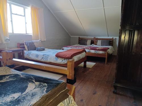 Drakensberg Mountain Retreat Barn House tesisinde bir odada yatak veya yataklar