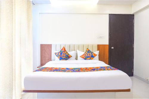 a bedroom with a large bed with colorful pillows at FabHotel Majestic Luxurious in Pune