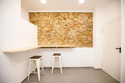 Hotel Casa Mas في يوريت دي مار: غرفة بها طابقين وجدار حجري