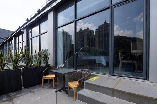 a balcony with a table and chairs and windows at Paco Hotel Jinfeng Metro Guangzhou-Free Shuttle Bus For Canton Fair-Self-service laundry in Guangzhou