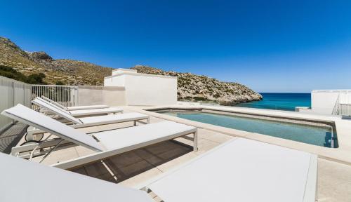 a villa with a swimming pool and the ocean at Hoposa Niu in Cala de Sant Vicent