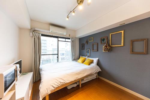 Una cama o camas en una habitación de 402 道頓堀側のお部屋 中心地へのアクセス抜群 ダブルベッド1台