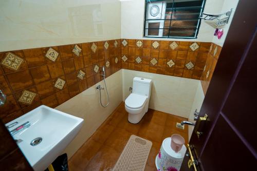 een kleine badkamer met een toilet en een wastafel bij Abhishta Agri Farm Stay in Kunigal