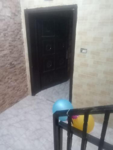 a room with a chair and a black door at Khalda tawn in Rujm ash Sharāʼirah