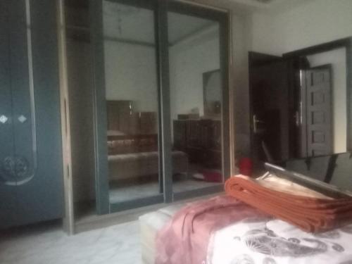 Zimmer mit einem großen Glasfenster und einem Bett in der Unterkunft Khalda tawn in Rujm ash Sharāʼirah