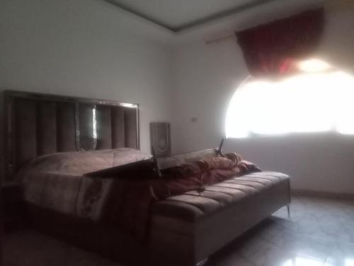 ein Schlafzimmer mit einem Bett und einem Sofa in einem Zimmer in der Unterkunft Khalda tawn in Rujm ash Sharāʼirah